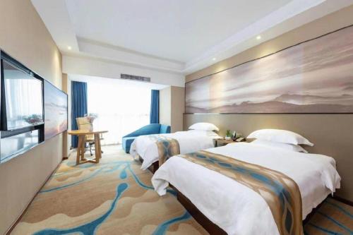 a hotel room with two beds and a flat screen tv at Guilin Manhatton Hotel Tianjie in Guilin