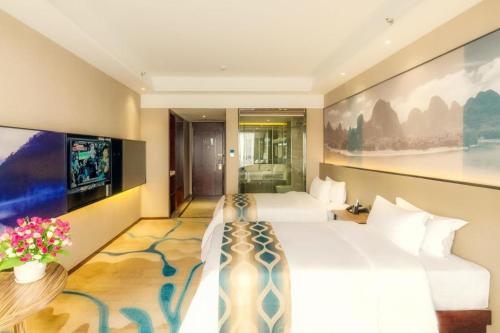 a hotel room with two beds and a tv at Guilin Manhatton Hotel Tianjie in Guilin