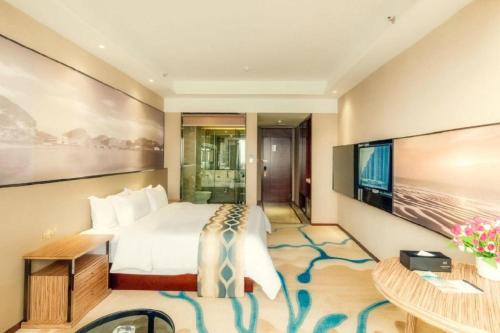 a hotel room with a bed and a flat screen tv at Guilin Manhatton Hotel Tianjie in Guilin