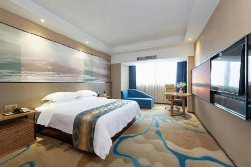 a hotel room with a large bed and a flat screen tv at Guilin Manhatton Hotel Tianjie in Guilin
