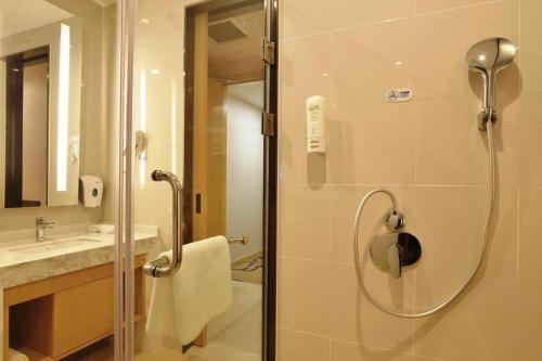 un baño con ducha y lavabo en Holiday Inn Express Jinan Exhibition Center By IHG, en Jinan