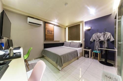 a bedroom with a bed and a desk with a computer at Some Motel in Suwon