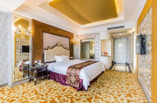pokój hotelowy z dużym łóżkiem i telewizorem w obiekcie Foshan Nanhai Huifeng Holiday Hotel w mieście Foshan