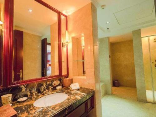 a bathroom with a sink and a large mirror at King Century Hotel in Zhongshan