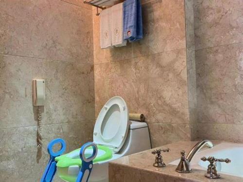 a bathroom with a toilet and a sink and scissors at King Century Hotel in Zhongshan