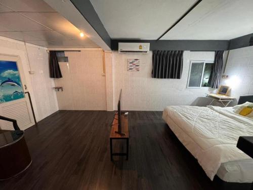 a bedroom with a bed and a desk with a laptop at Near beach hostel in Bang Tao Beach