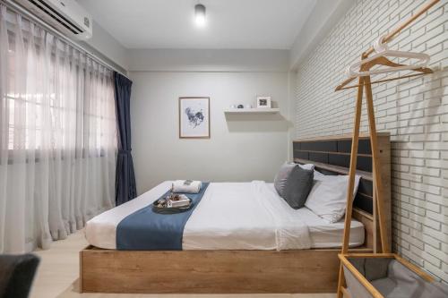 Un dormitorio con una cama con marco de cama de madera. en 4BR house MRT subway 250m Chatujak Market wi-fi, en Bangkok