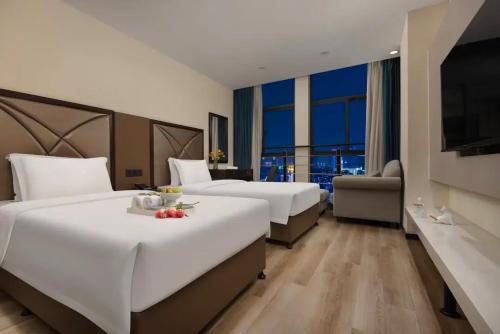 a hotel room with two beds and a television at Manston Hotel Gaoxin Science Avenue Subway Station Branch in Hefei