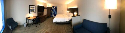a small hotel room with a bed and a couch at Holiday Inn Express and Suites Hannibal-Medical Center By IHG in Hannibal
