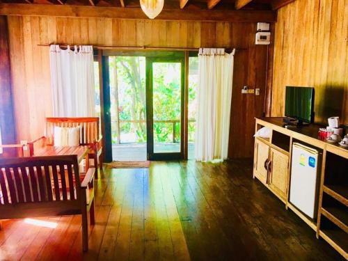 ein Wohnzimmer mit einem Sofa, einem Tisch und einer Tür in der Unterkunft Chivaree Hotel and Resort in Chanthaburi