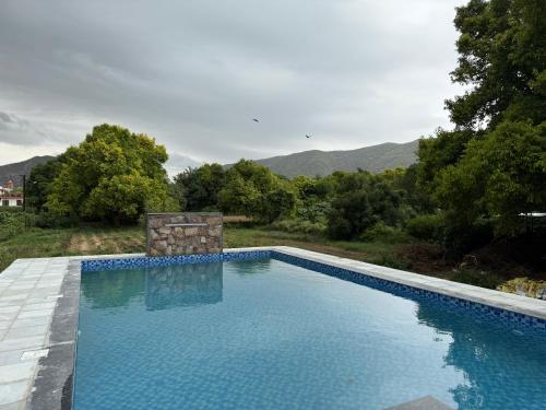 a swimming pool with a mountain in the background at Heli Pushkar in Pushkar
