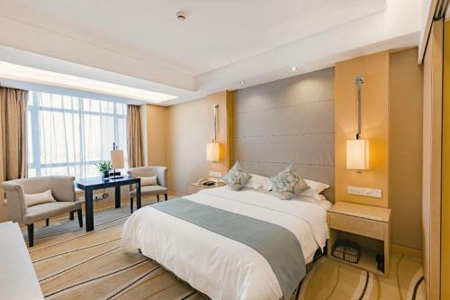 a hotel room with a large bed and a desk at New Century Pujiang Hotel in Xiajizhai