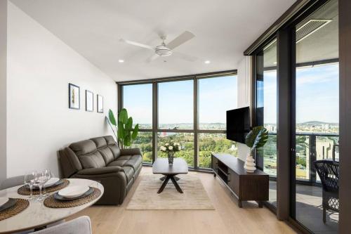 a living room with a couch and a tv at New Luxe 2BR Queens Wharf Apt in Brisbane