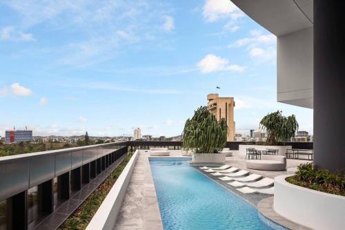 a swimming pool on the roof of a building at New Luxe 2BR Queens Wharf Apt in Brisbane