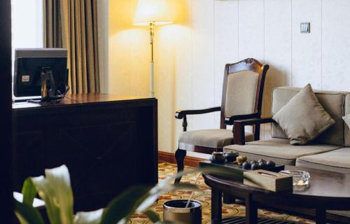 a living room with a couch and a chair at Manhatton Hotel Beihai in Beihai