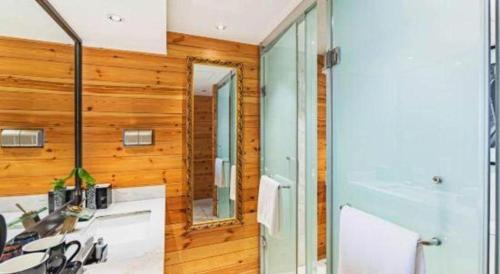 a bathroom with a shower and a sink and a mirror at Zaozhuang Hotel in Zaozhuang