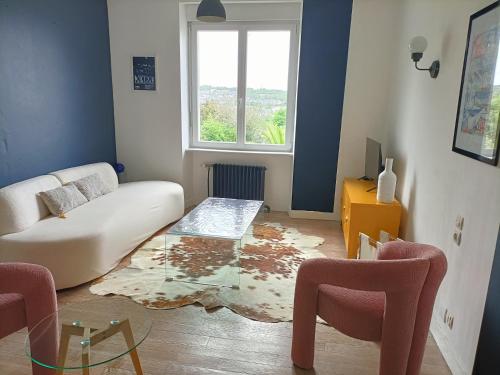 a living room with a couch and a glass table at Maison au calme, proche du centre de Landerneau in Landerneau