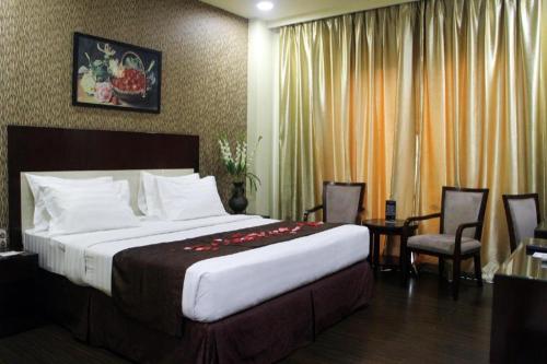 a hotel room with a bed and a table and chairs at Narita Classic Hotel in Tangerang