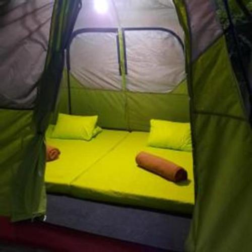 a bed in a green tent with a hot dog at Herman Lantang Camp in Bogor