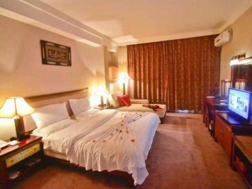 a hotel room with a bed and a television at Lijiang Liwang Hotel in Lijiang