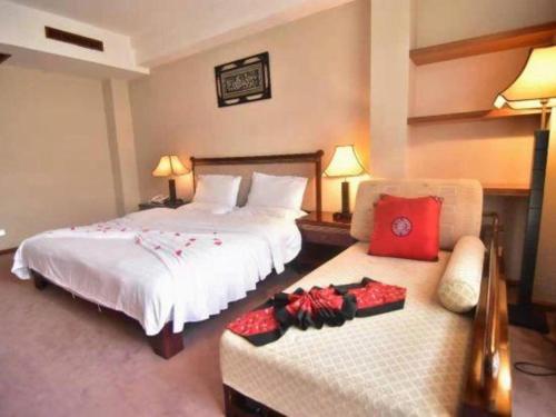 a hotel room with two beds and a chair at Lijiang Liwang Hotel in Lijiang