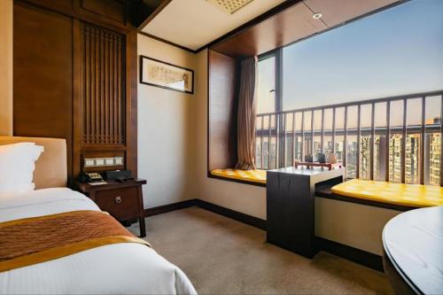 a room with a bed and a window with a balcony at Yitel Collection Chengdu Kuanzhai Alley Chutian Junlin in Chengdu