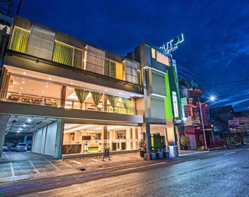 a building on the side of a street at night at Lotus Hotel Subang in Bandung