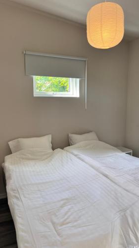 a bedroom with a large white bed with a window at Villa Vinja in Ystad