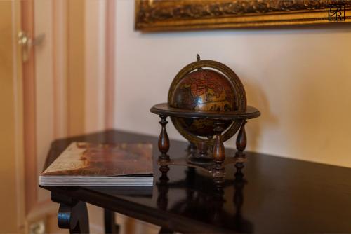 a table with a book and a globe on it at Palazzo Rossi, Historic Boutique Home in Marche in Sarnano