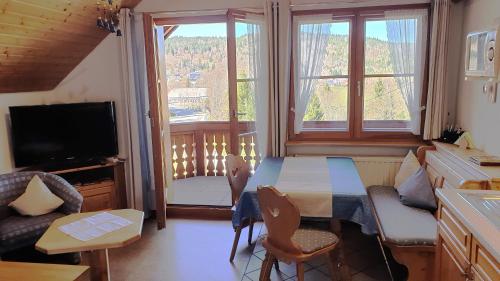 a living room with a table and chairs and a television at Appartement In Wittenschwand in Wittenschwand