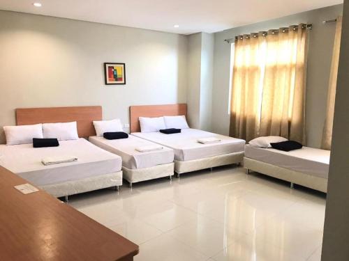 a room with two beds and a table at Country Chateau Hotel in Kaybagal