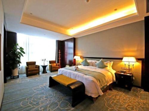 a bedroom with a large bed and a large window at Weida Hotel Jinhua in Jinhua