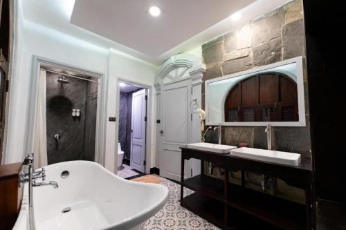 a bathroom with a white tub and a sink at Mylaohome Guesthouse & Spa in Luang Prabang