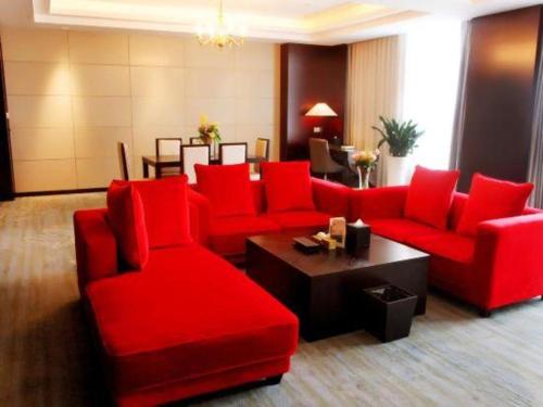 a living room with red chairs and a table at Weida Hotel Jinhua in Jinhua