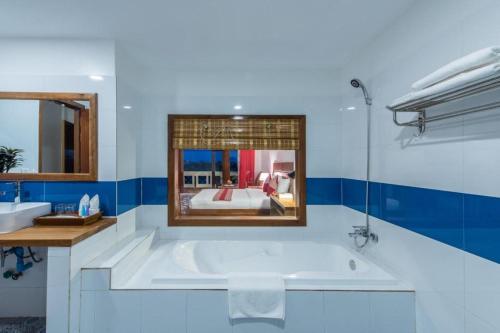 a bathroom with a large tub and a bedroom at Amour D' Angkor in Phumĭ Réach Born (1)