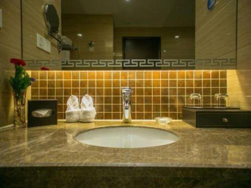 a bathroom with a sink and a mirror at Huangshan International Hotel in Huangshan