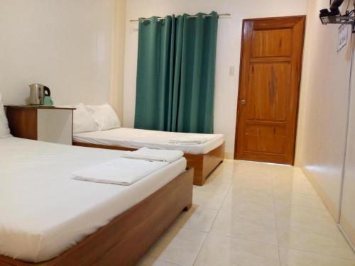 a room with two beds and a wooden door at Joaquim's Lodge in Luka