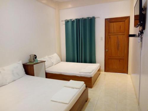 a room with two beds and a door at Joaquim's Lodge in Luka
