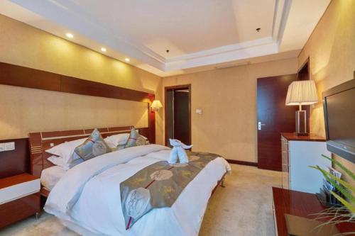 a bedroom with a bed with a teddy bear on it at Huangshan International Hotel in Huangshan