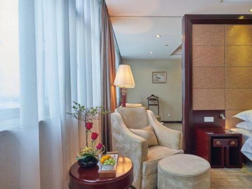 a hotel room with a chair and a table and a room at Huangshan International Hotel in Huangshan