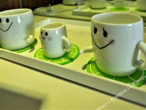 two cups on a tray with faces on them at Huangshan International Hotel in Huangshan