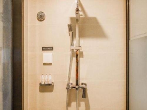 a bathroom with a shower with a comb and tooth brushes at Lavande Hotel Zhaoqing government Dinghu Mountain Scenic Spot in Zhaoqing