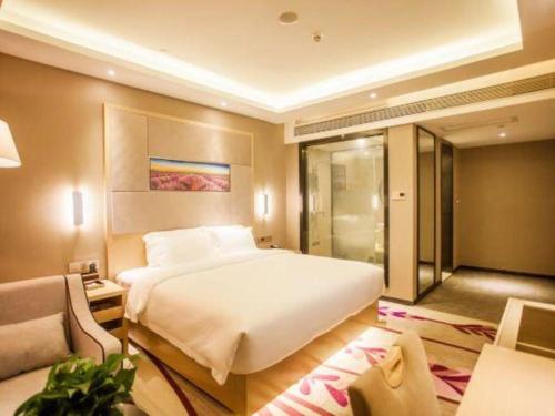 a bedroom with a large white bed and a couch at Lavande Hotel Zhaoqing government Dinghu Mountain Scenic Spot in Zhaoqing