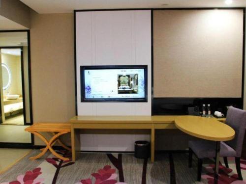a room with a desk with a television on it at Lavande Hotels·Qingyuan Jinbiwan in Qingyuan