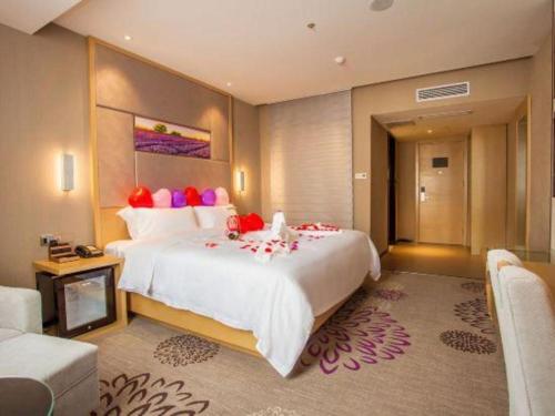 a large bedroom with a large bed with colorful pillows at Lavande Hotel Zhaoqing government Dinghu Mountain Scenic Spot in Zhaoqing