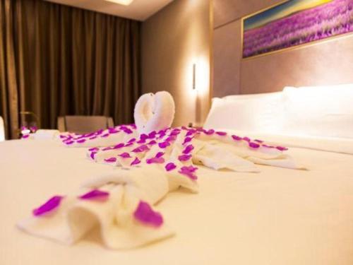 a hotel room with purple flowers on a bed at Lavande Hotel Zhaoqing government Dinghu Mountain Scenic Spot in Zhaoqing
