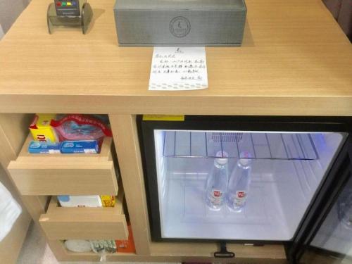 a small refrigerator with two water bottles in it at Lavande Hotels·Qingyuan Jinbiwan in Qingyuan