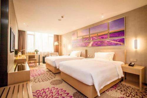 a hotel room with two beds and a desk at Lavande Hotel Zhaoqing government Dinghu Mountain Scenic Spot in Zhaoqing