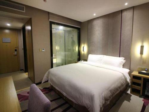 a bedroom with a large bed and a walk in shower at Lavande Hotels·Qingyuan Jinbiwan in Qingyuan