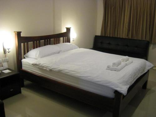 a bed with two teddy bears laying on it at The Park Nangrong Resort in Nang Rong